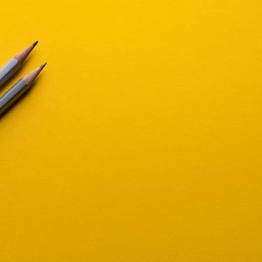 黄色のキャンバスに鉛筆が揃えて置かれる画像